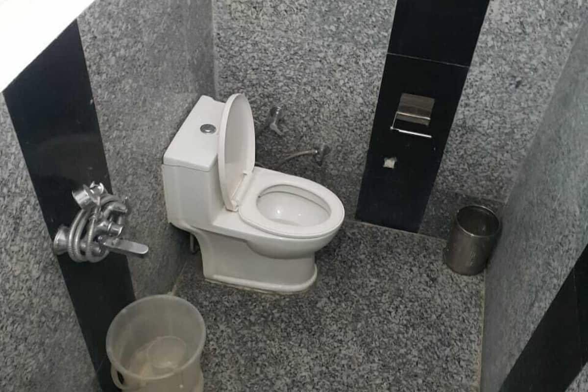 Un baño pequeño con un inodoro blanco, un lavabo y un cubo de basura.