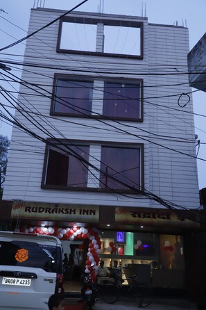 A multi-story building with a sign for 'Rudraaksh Inn' indicating a hotel.