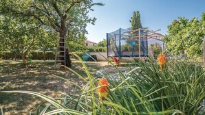 A garden with a tree, a ladder, and a blue structure. - Apartment 1495/14369 (Istria - Banjole), 500m from the beach (Banjole)