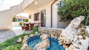 A stone house with a patio, a small pond, and a dining area. - Apartment 1495/14369 (Istria - Banjole), 500m from the beach (Banjole)