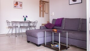 A modern living room with a grey sofa, a small table, and metal chairs. - Apartment 1496/14455 (Istria - Pula), 2500m from the beach (Pula)
