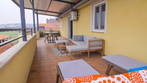 Enjoy a peaceful moment on the balcony with a wooden table and comfortable seating areas.