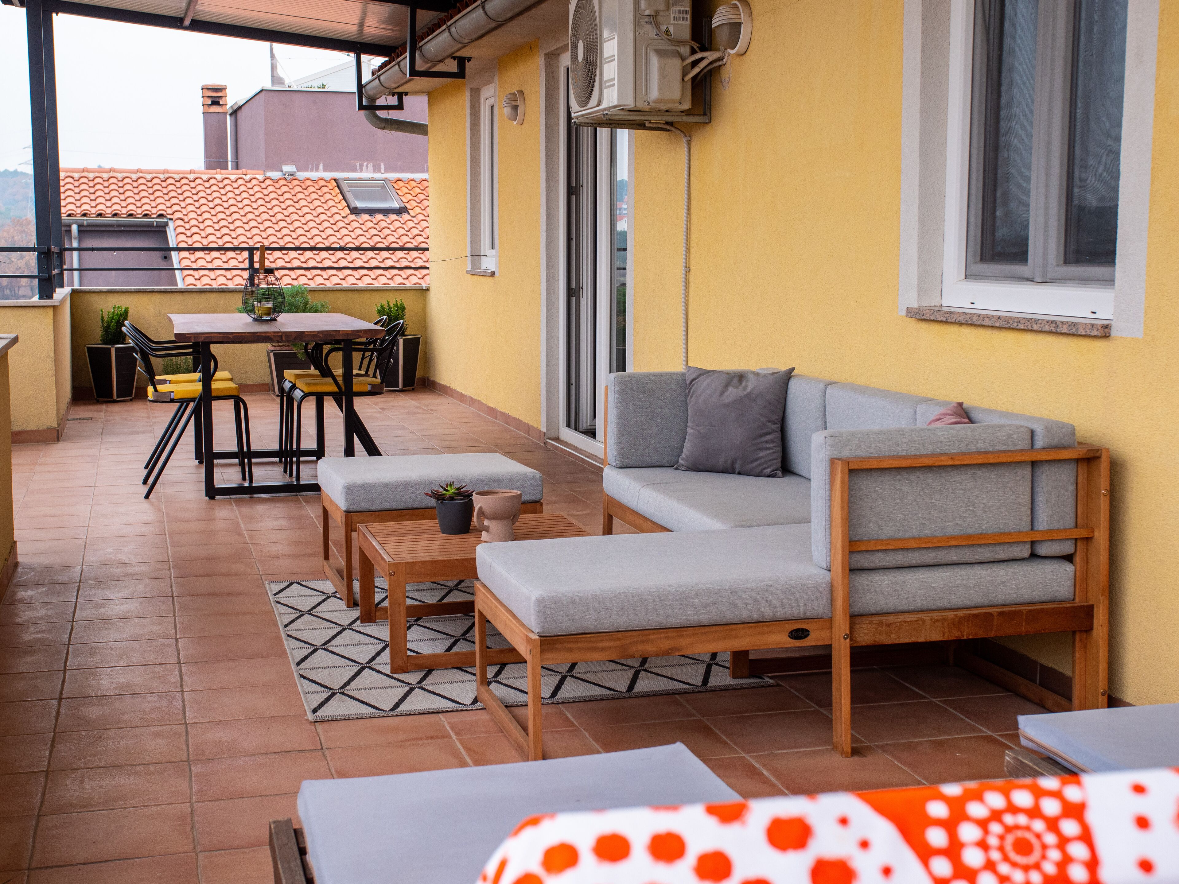 A patio with a sofa, chairs, and a table.