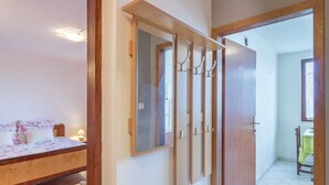 Un dormitorio con cama, espejo y armario.