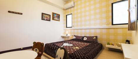 A small, cozy room with a bed, a chair, a table, and a window.