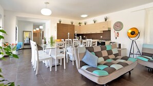 A modern living room with a sofa, dining table, chairs, and a kitchen area. - Villa 1519/15239 (Istria - Žminj), 25000m from the beach (Žminj)