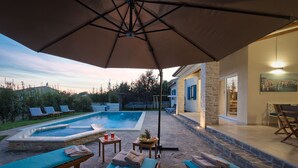 An outdoor pool area with lounge chairs, a table with drinks, and a fruit bowl. - Villa 1521/15241 (Istria - Žminj), 25000m from the beach (Žminj)