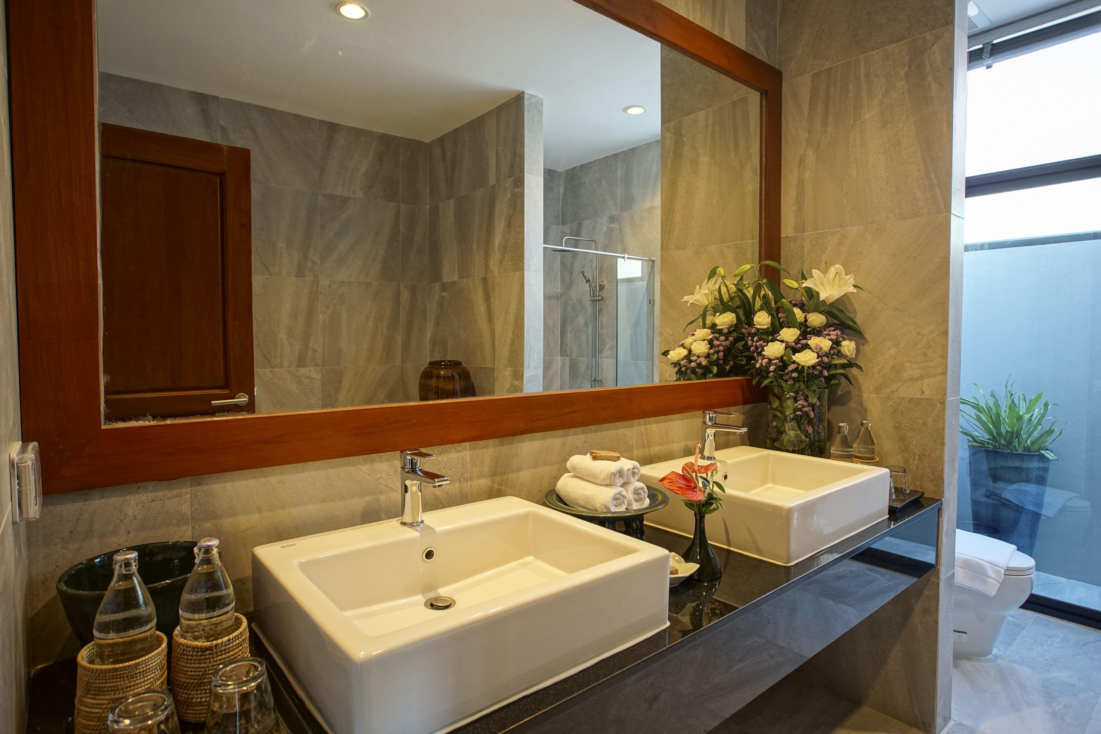 A bathroom with two sinks, a large mirror, and a shower area.