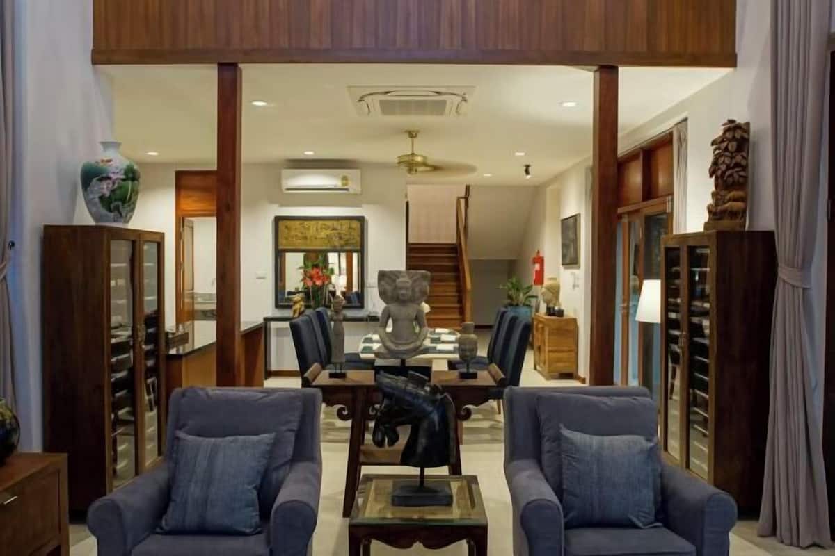 Amplia sala de estar con comedor, que incluye un conjunto de sofá, una mesa de centro y una estatua decorativa.