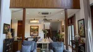 Amplia sala de estar con techo alto, balcón y comedor con dos sofás y una mesa de centro.