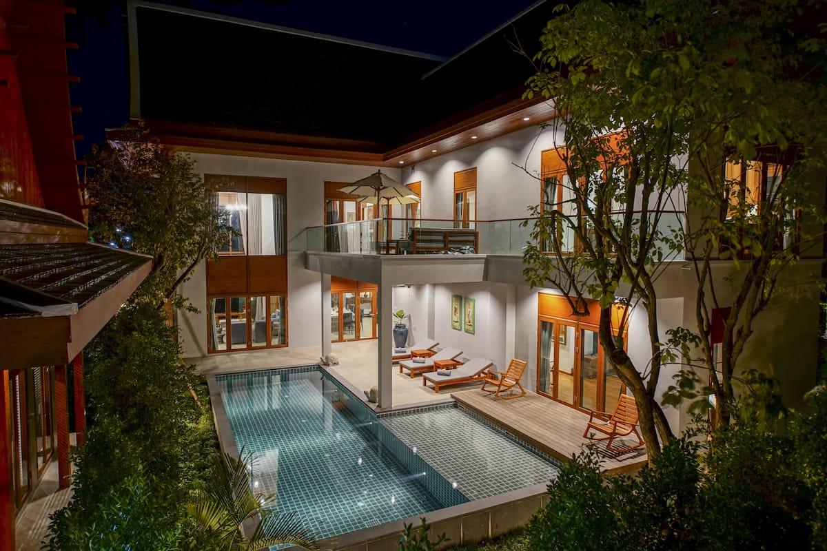 Una casa moderna con piscina, balcón y zona de comedor.