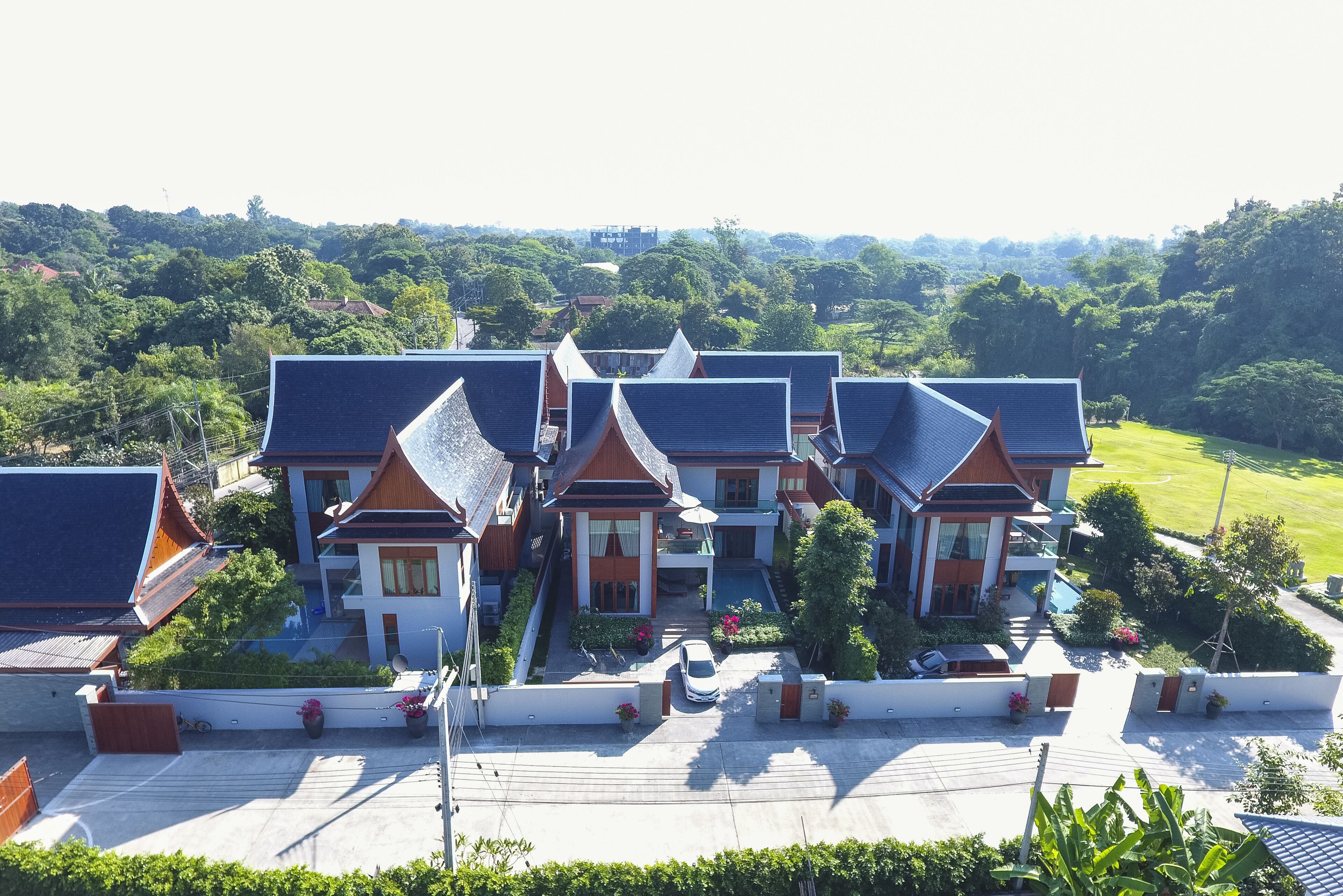 A traditional multi-story building with a central courtyard, surrounded by lush greenery.