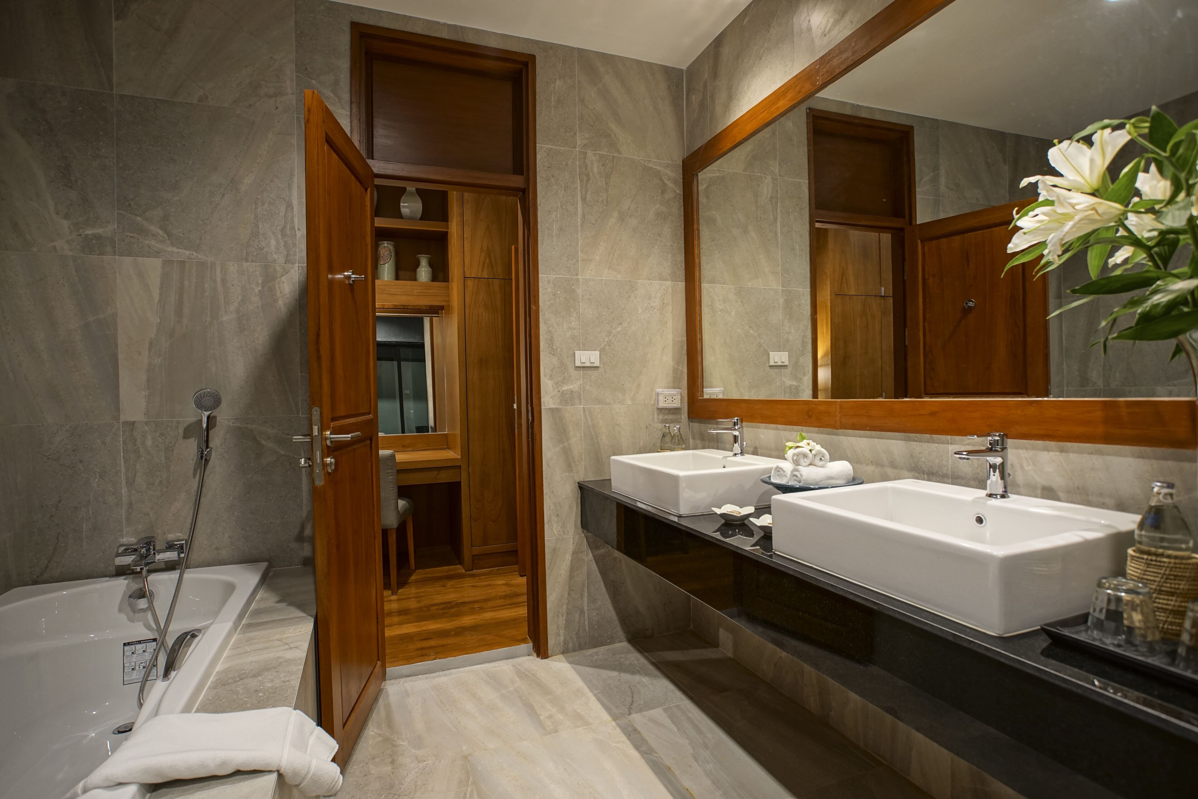 Un baño moderno con dos lavamanos, un espejo grande y una zona de ducha.