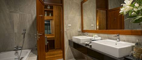 Un baño moderno con dos lavamanos, un espejo grande y una zona de ducha.