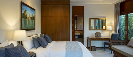 Een hotelkamer met twee bedden, een bureau, een stoel, een plafondventilator en een groot raam.