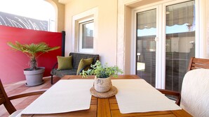 A wooden table with two woven placemats, a potted plant, and a small woven basket. - Apartment 1531/15377 (Istria - Vinkuran), 500m from the beach (Vinkuran)