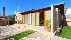 A modern house with a stone patio, a small lawn, and potted plants. - Apartment 1531/15385 (Istria - Vinkuran), 500m from the beach (Vinkuran)