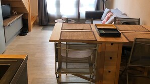 A cozy room with a wooden desk, a chair, a bed with pillows, a lamp, and a window with curtains. - Air-conditioned house with pool, bikes and terrace 800 metres from the beach (Saint-Cyprien Plage)