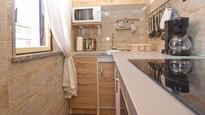 A compact kitchen with a microwave, sink, and coffee maker.