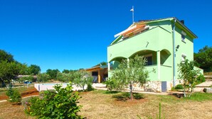 A green building with a flag, a swimming pool, and a well-maintained garden. - House 1548/15836 (Istria - Fažana), 3150m from the beach (Fažana)