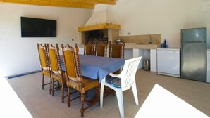 A dining area with a wooden ceiling, a TV mounted on the wall, a kitchen with a stove, and a refrigerator. - House 1548/15836 (Istria - Fažana), 3150m from the beach (Fažana)