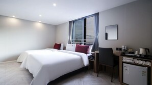 A modern hotel room with a large bed, a desk, and a view of the city through the window. - Busan Maron Hotel Nampo (Busan)