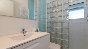A bathroom with a white sink, a mirror, a towel, and a glass block wall. - Charlotte - Benissa, Costa Blanca (Benissa)