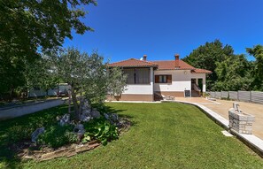A two-story house with a red-tiled roof, a small porch, and a well-maintained lawn. - Apartment 1561/15973 (Istria - Žminj), 20000m from the beach (Žminj)