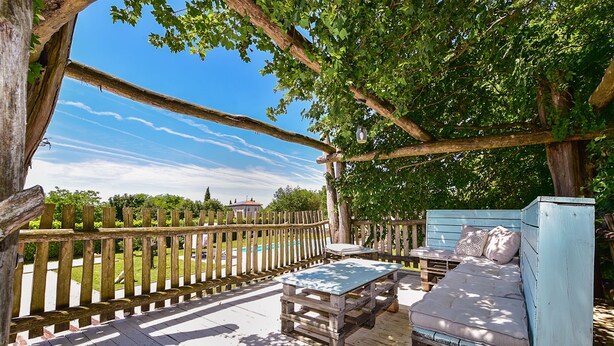 A wooden deck with a rustic bench and a sofa, surrounded by a wooden fence and trees. - Apartment 1561/15973 (Istria - Žminj), 20000m from the beach (Žminj)