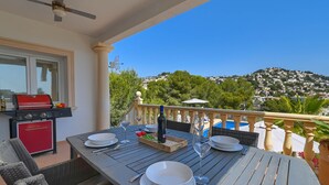 An outdoor dining area with a table set for four, a grill, and a view of a hillside. - Modern and comfortable holiday home in Benissa, Costa Blanca, Spain  with private pool for 6 persons (Benissa)