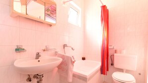 Un baño con dos lavamanos, un inodoro y una cortina de ducha.