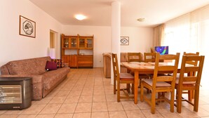 Una sala de estar con sofá, una mesa con sillas, un armario y un calentador.