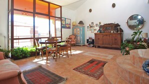 A spacious living room with a dining area, large windows, a chandelier, and a variety of decorative items. - Apartment 1571/24205 (Istria - Pula), 1500m from the beach (Pula)