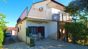 A two-story house with a balcony, stone walls, and a paved courtyard. - Apartment 1576/16148 (Istria - Medulin), 1000m from the beach (Medulin)