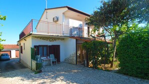 A two-story house with a stone-paved courtyard, a balcony, and a car parked in the driveway. - Apartment 1576/16148 (Istria - Medulin), 1000m from the beach (Medulin)