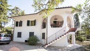 Une maison à deux étages avec un escalier menant à un balcon.