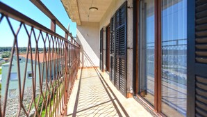 A balcony with a metal railing, large windows with shutters, and a view of a residential area. - Apartment 1586/16261 (Istria - Pula), 1000m from the beach (Pula)