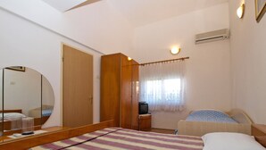 A bedroom with a bed, a mirror, a wardrobe, a television, and a window with curtains. - Apartment 1588/16265 (Istria - Pula), 1500m from the beach (Pula)