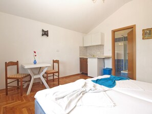 A small, well-lit room with a bed, a desk, a chair, a small kitchenette, and a bathroom with a shower. - Apartment 1598/16342 (Istria - Fažana), 500m from the beach (Fažana)