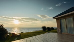 A patio with a view of the ocean at sunset. - Resort villa miko (Oshima)