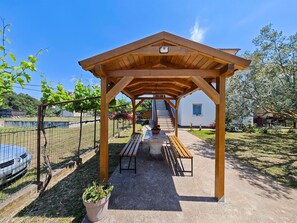 A covered outdoor seating area with benches and a pergola structure.