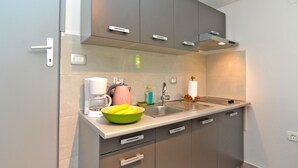 A compact kitchen with grey cabinets, a stainless steel sink, and a coffee maker. - Apartment 1642/16897 (Istria - Pula), 5000m from the beach (Pula)