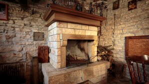A stone fireplace with a wooden mantel, surrounded by stone walls and a rustic wooden chair. - Apartment 1655/17138 (Istria - Matohanci), 9000m from the beach (Matohanci)
