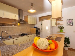 A modern kitchen with beige cabinets, a granite countertop, a built-in oven, and a refrigerator. - House 1678/17379 (Istria - Stinjan), 850m from the beach (Stinjan)