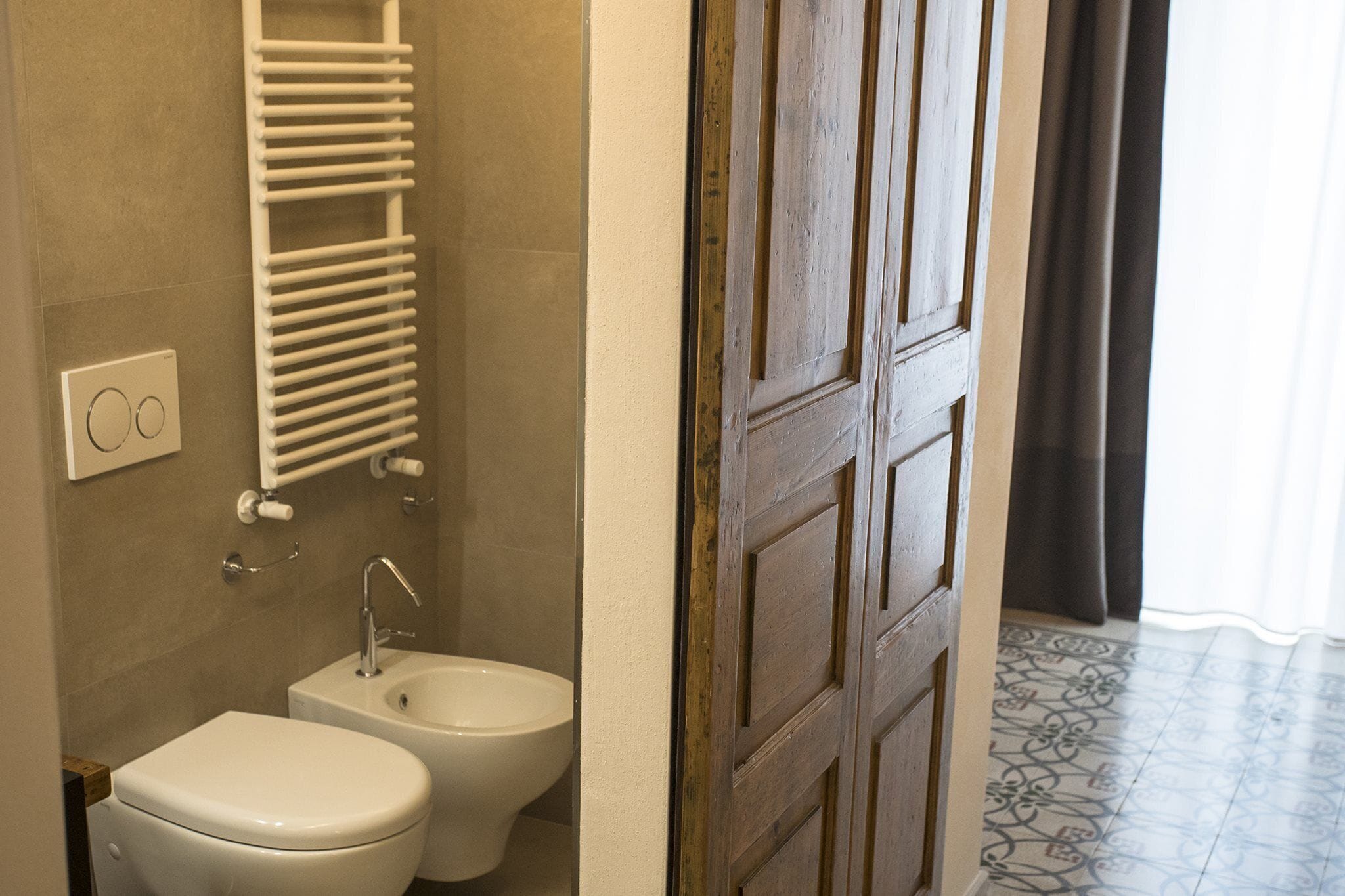 Ein Badezimmer mit Toilette, Bidet und Handtuchhalter.