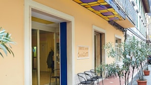 Un hôtel à la façade jaune, aux portes bleues, et dont l’enseigne indique qu’il s’agit d’un établissement quatre étoiles.