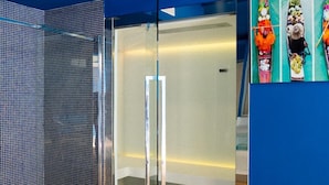Un intérieur moderne avec un mur d’accent bleu, une cloison en verre et un plancher en bois.