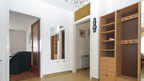 A hallway with a wooden wardrobe, a mirror, and a radiator.