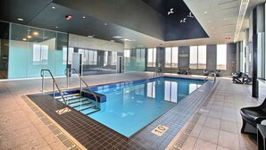 Une piscine intérieure à l’eau claire, un panneau indiquant l’interdiction d’accès et le chiffre 10 peint sur le sol.