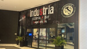 Un bar-restaurant moderne appelé « Industria », dont l’enseigne indique qu’il propose une cuisine italienne.